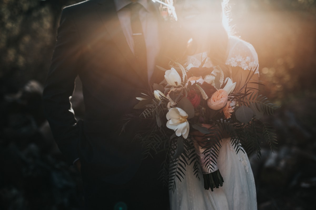 Bride and groom standing at ceremony altar during sunset